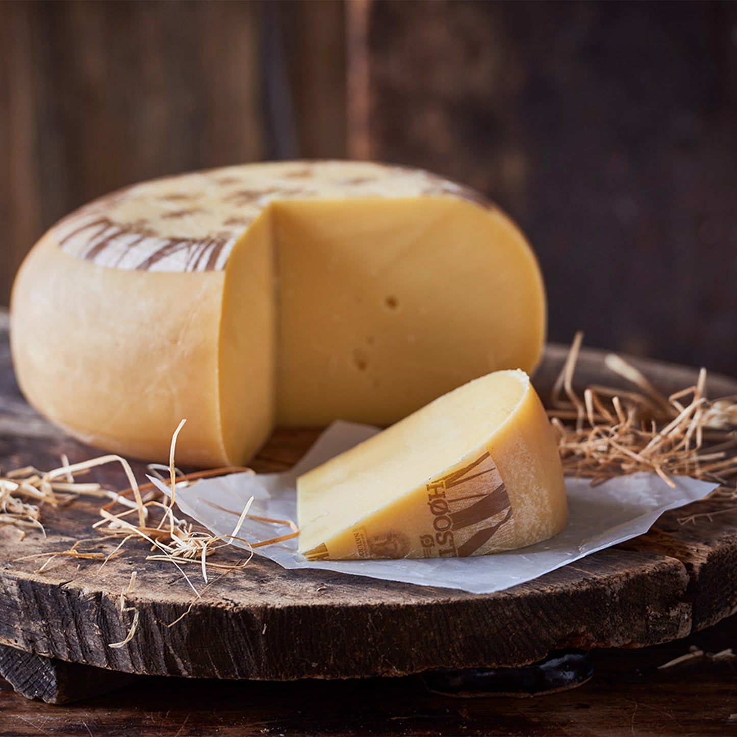 Modnet ostehjul med et stykke skåret af på træbræt